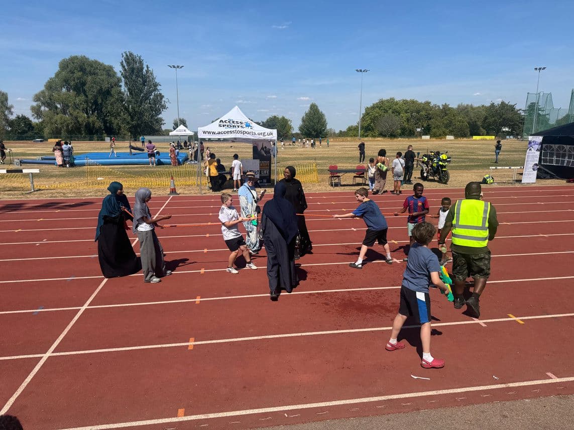 Children playing games on a running track at the Family Fun Day