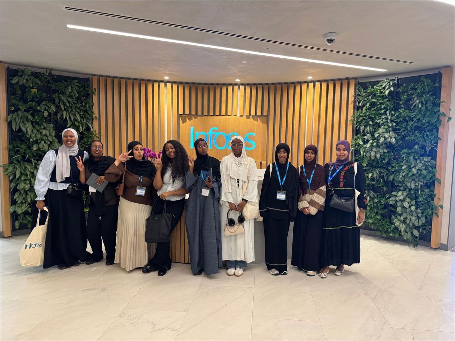 Young women from the programme standing together in an office reception